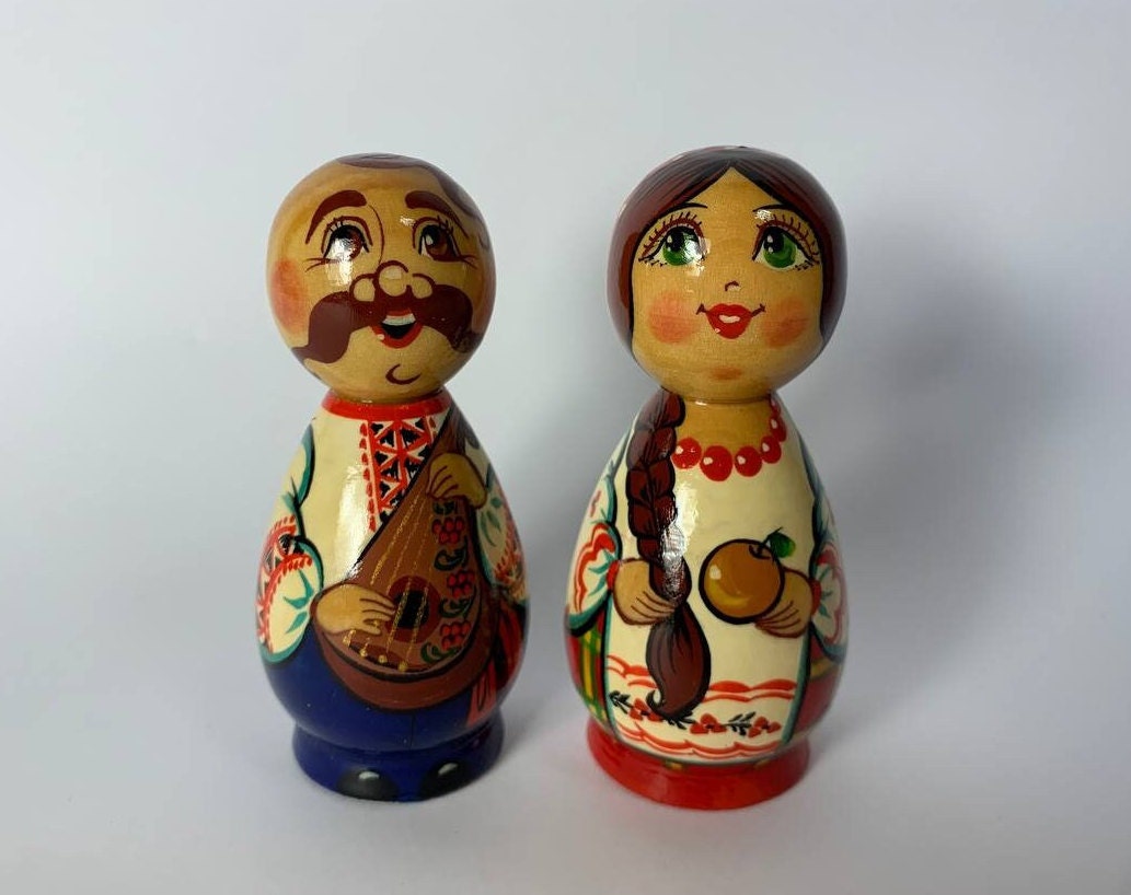 Hand-painted wooden figurines of Ukrainian folk couple Kozak and girl, vibrant traditional design, cultural gift.