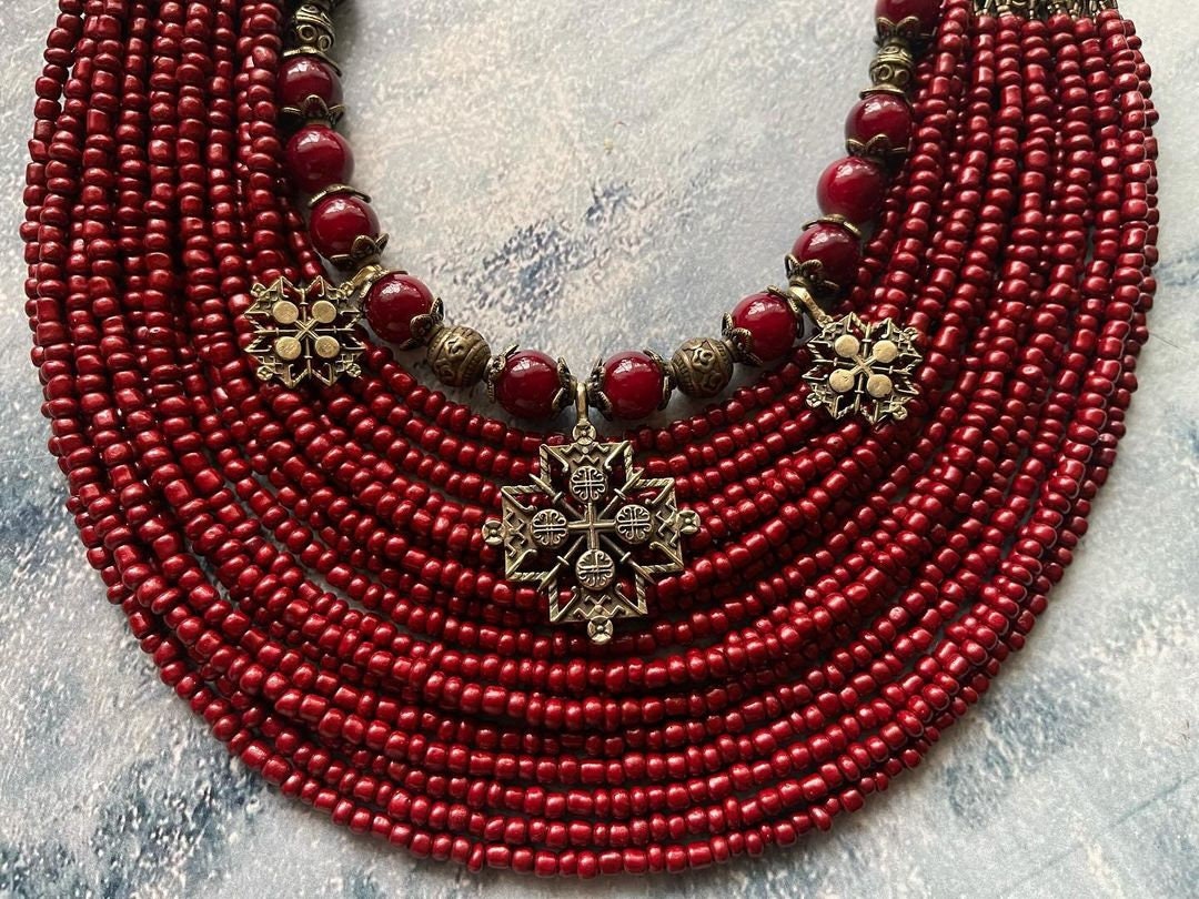 Handmade red Ukrainian multi-row necklace with antique-style glass beads and intricate metal fittings.