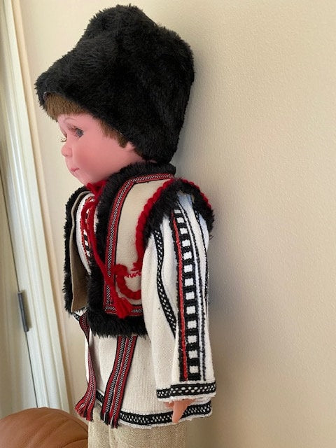 Handmade Ukrainian boy doll in traditional Carpathian outfit with hand-embroidered details and black fur hat.