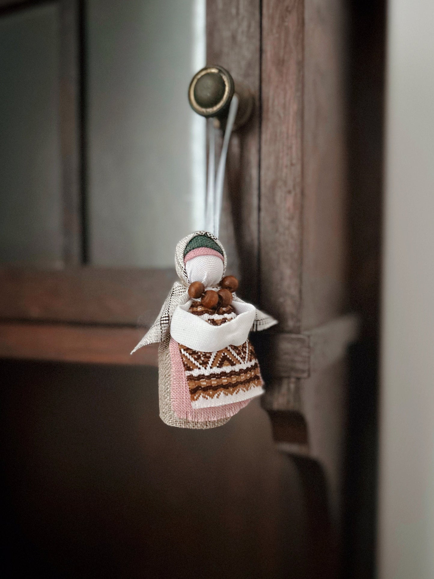 Handmade Ukrainian Motanka Doll "Little Bereginiya" with horseshoe, charming folk art amulet hanging for home decor and luck.