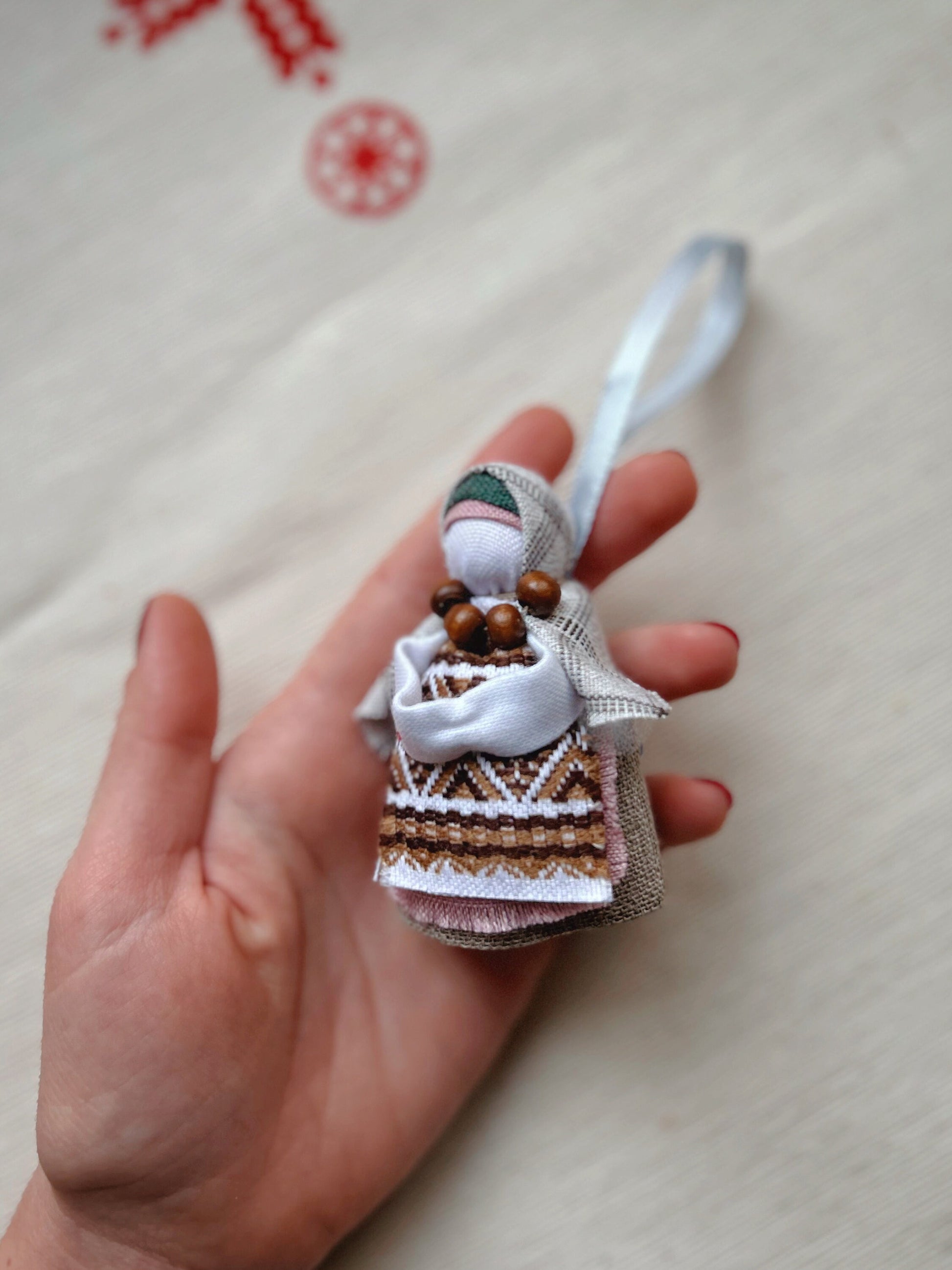 Handmade Motanka Ukrainian Doll "Little Bereginiya" with horseshoe, held in hand, symbolizing luck and protection.