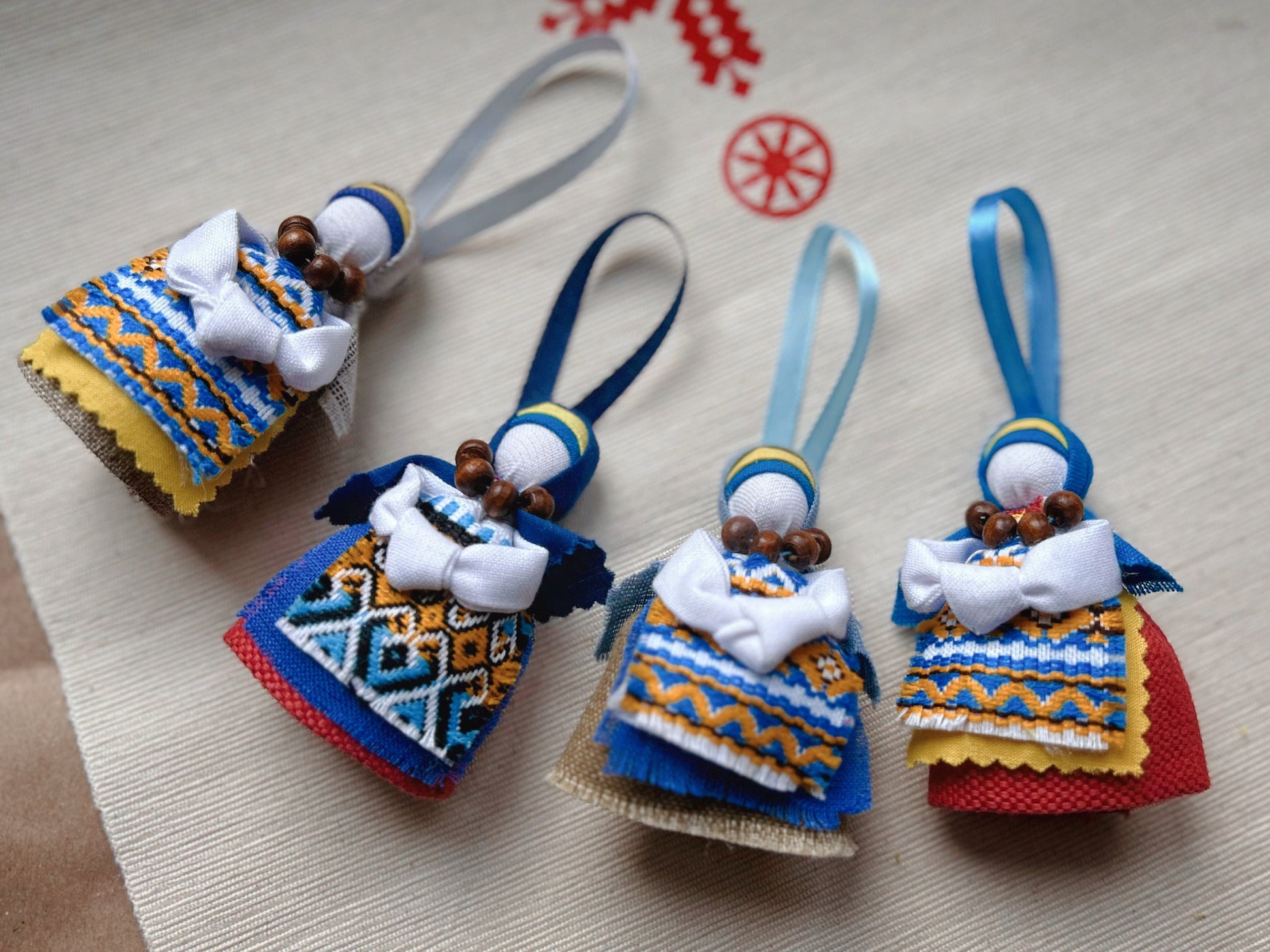 Handmade Ukrainian Motanka Dolls with colorful folk attire, blue ribbons, and beaded details for home decor and positive energy.