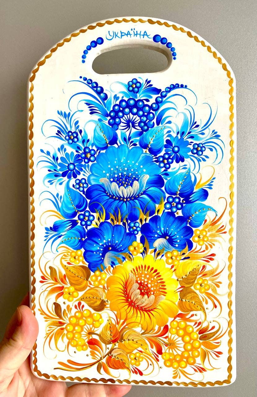 Hand-painted wooden cutting board with yellow-blue Petrykivka floral design, Ukrainian folk art kitchen decor.