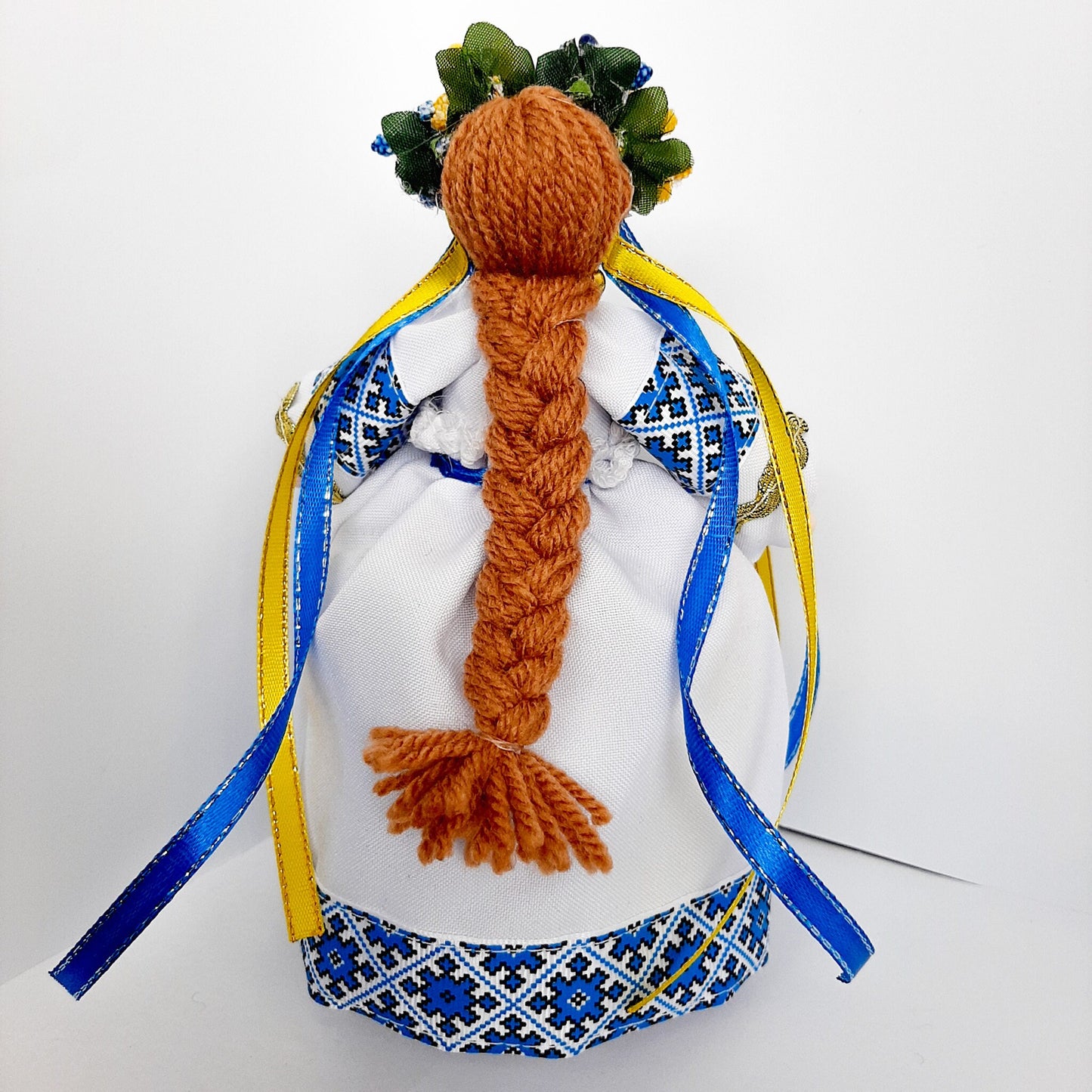 Traditional Ukrainian Motanka doll with braided hair, blue and white attire, symbolic of home protection and prosperity, perfect housewarming gift.