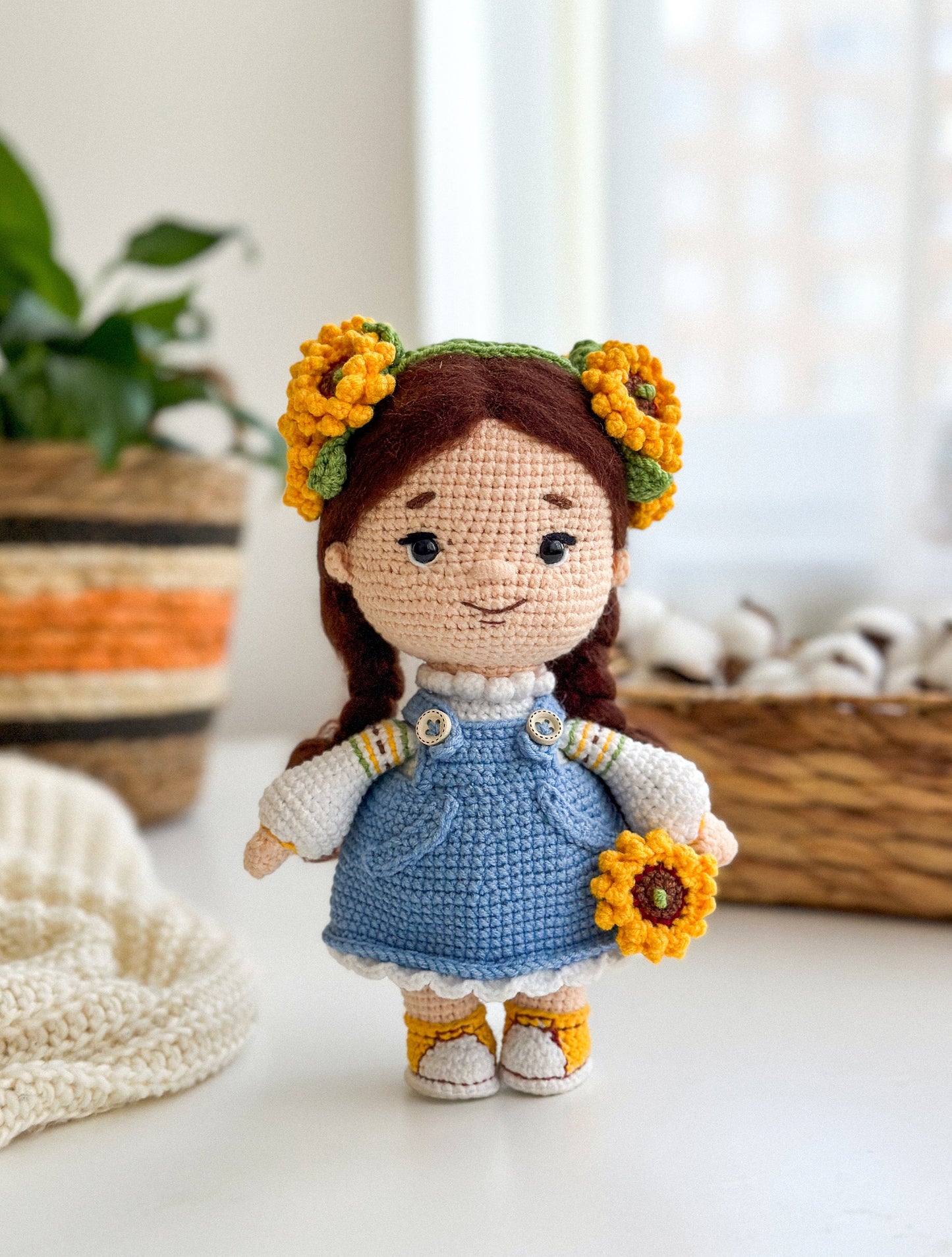 Handmade knitted doll with sunflower headband, wearing a blue dress, symbolizing Ukrainian culture. Perfect keepsake gift.