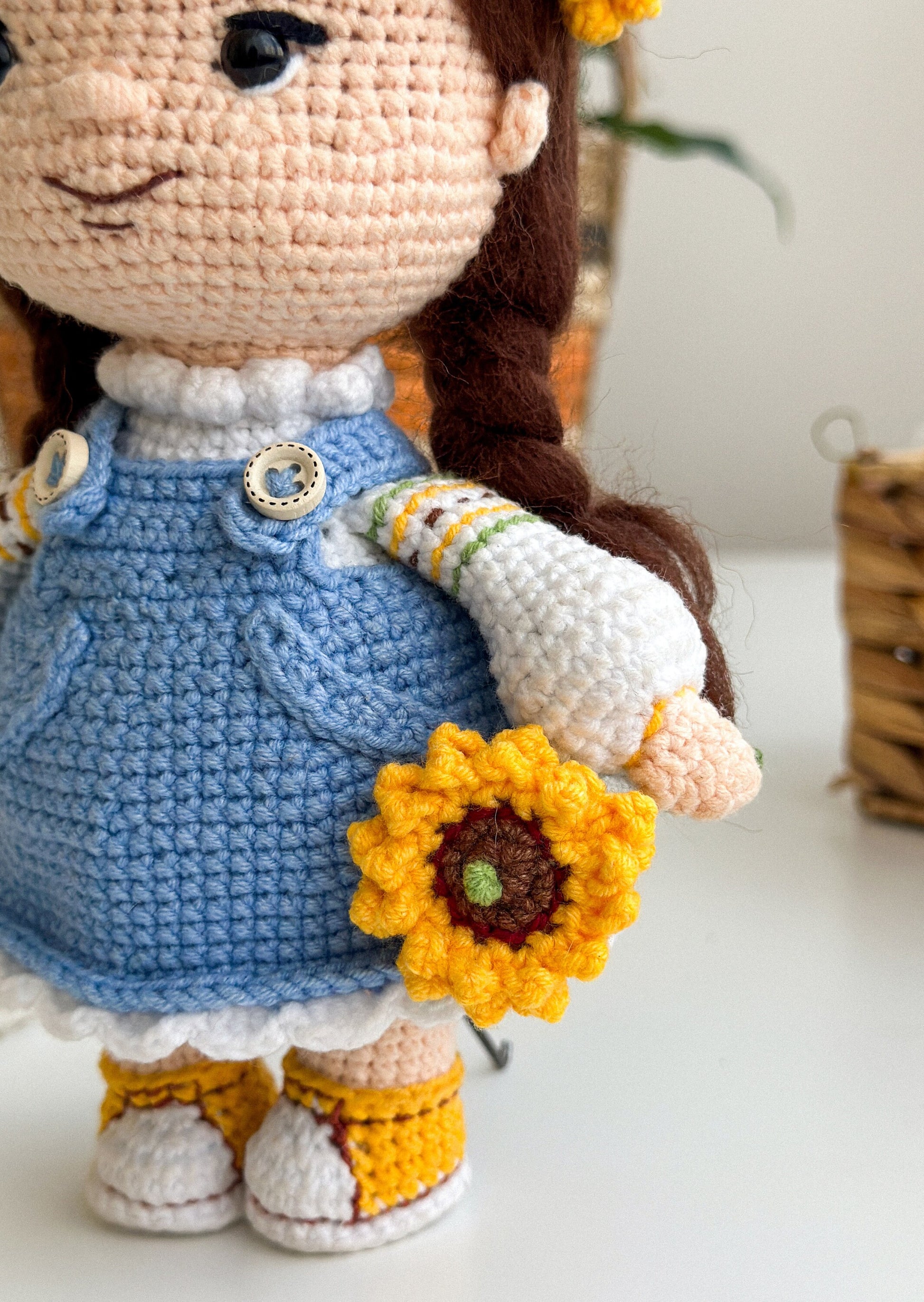 Handmade knitted doll with blue dress and sunflower, Ukrainian themed soft toy, perfect gift with intricate details.