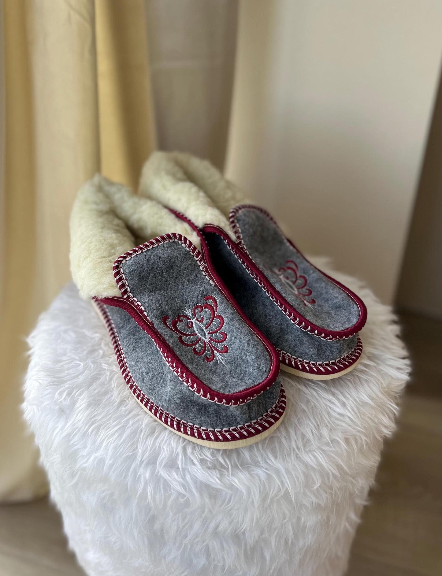 Handmade Carpathian wool slippers with Hutsul embroidery, showcasing Ukrainian craftsmanship and heritage.