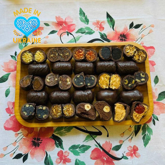 Artisanal Ukrainian chocolates with fruit and nuts on a floral tablecloth, perfect gourmet gift.