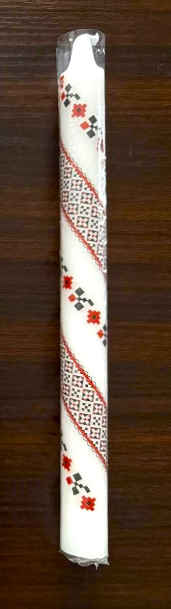 Handmade Ukrainian 10" taper candle with red and green festive design on a wooden background.