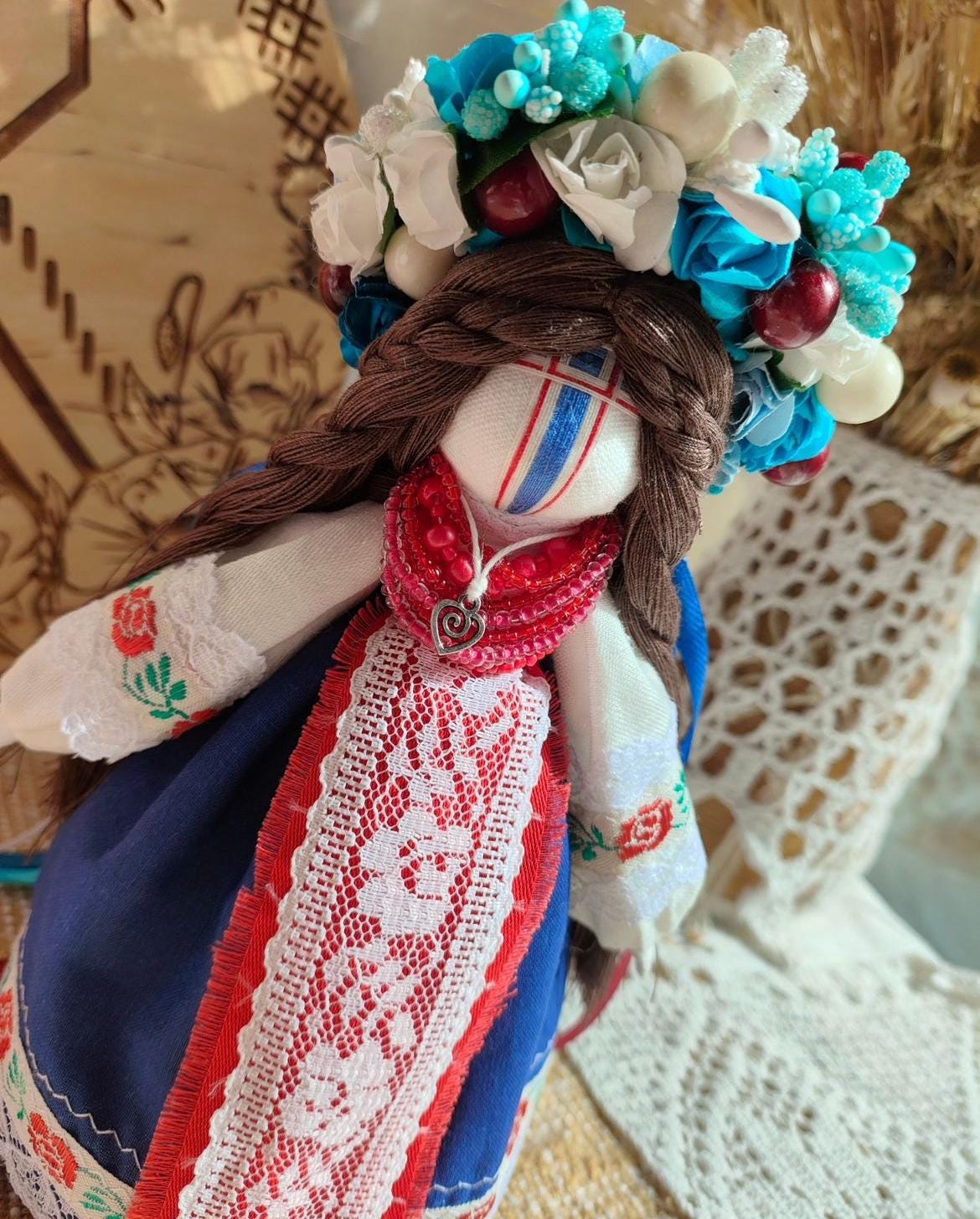 Handmade ethnic motanka doll with vibrant floral headpiece and traditional embroidery, symbolizing protection and wisdom.