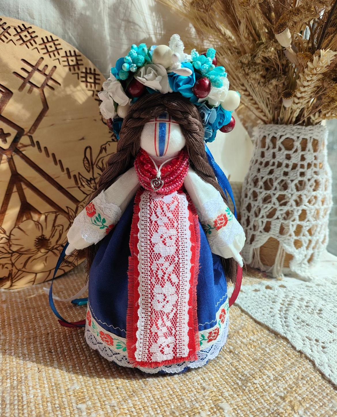 Handmade ethnic motanka doll with floral crown, featuring traditional attire and vibrant details, symbolizing protection and prosperity.