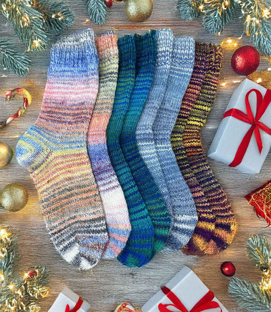 Colorful hand knitted wool socks, rainbow winter socks, perfect Christmas gift, surrounded by festive decorations and gifts.