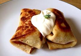 Alt Tag: Homemade Ukrainian crepes with sour cream, featuring thin golden-brown blini filled with a savory option. Frozen food offering.