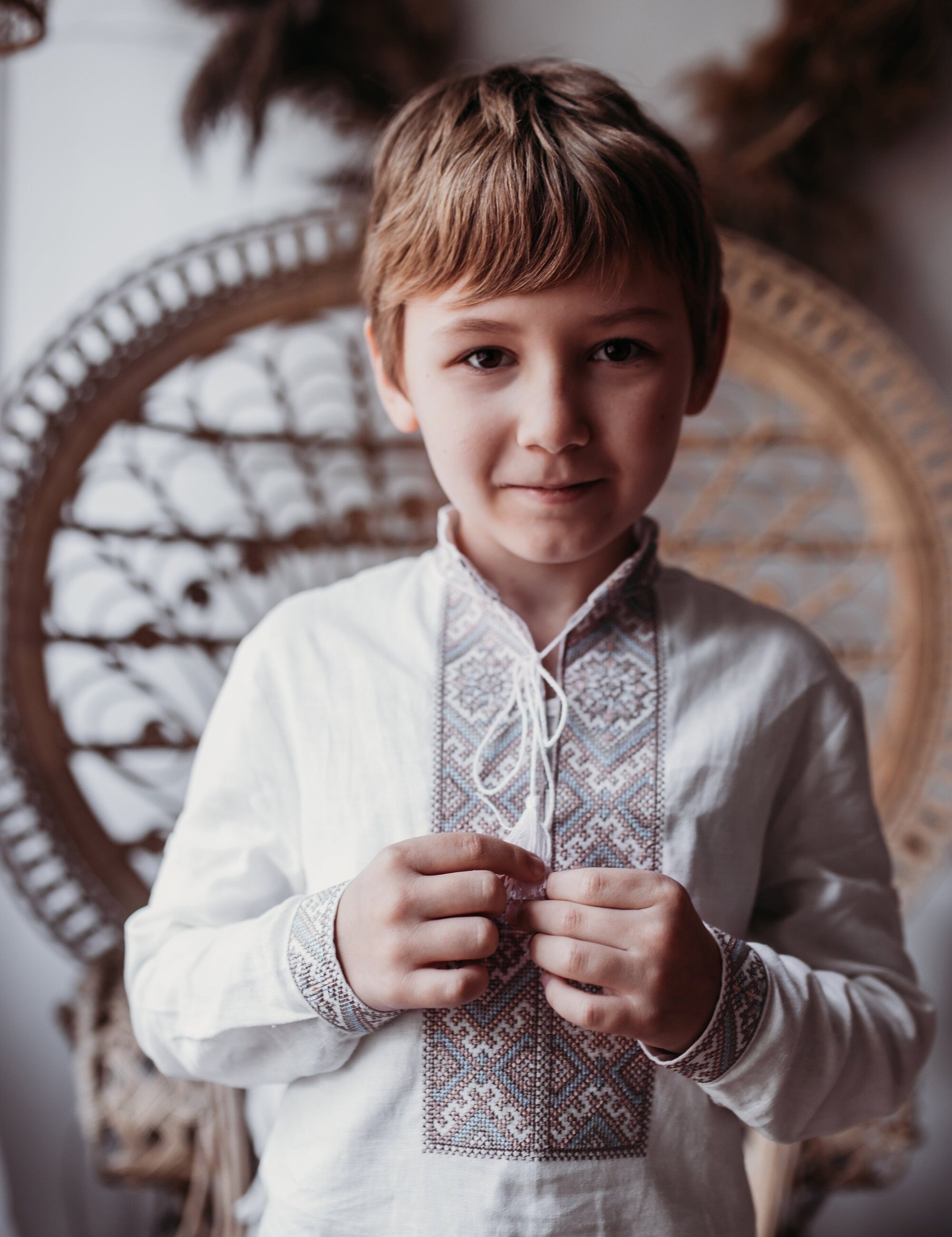 Boy wearing a Ukrainian Vyshyvanka shirt with traditional brown and blue embroidery, showcasing heritage and style in a comfortable fit.