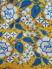 Detail of floral embroidery on mustard linen Vyshyvanka dress for girls, showcasing traditional Ukrainian folk patterns.