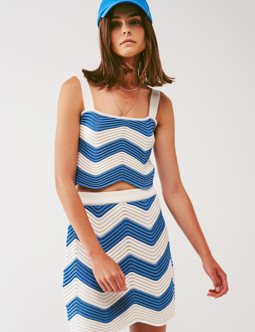 Woman wearing Ismira Scallop Bardot Top in rib-knit white and blue with bohemian style and summer ease.