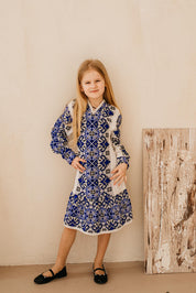 Young girl wearing a traditional Ukrainian knitted embroidered dress with blue patterns, perfect for cultural events and celebrations.