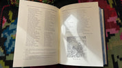 Open pages of "Kobzar" English Luxury Edition by Taras Shevchenko, featuring poetry and an illustration, on a colorful background.
