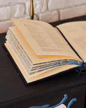 Open luxury edition of 'Kobzar' by Taras Shevchenko, leather-bound with decorative edges, showcasing handmade craftsmanship.