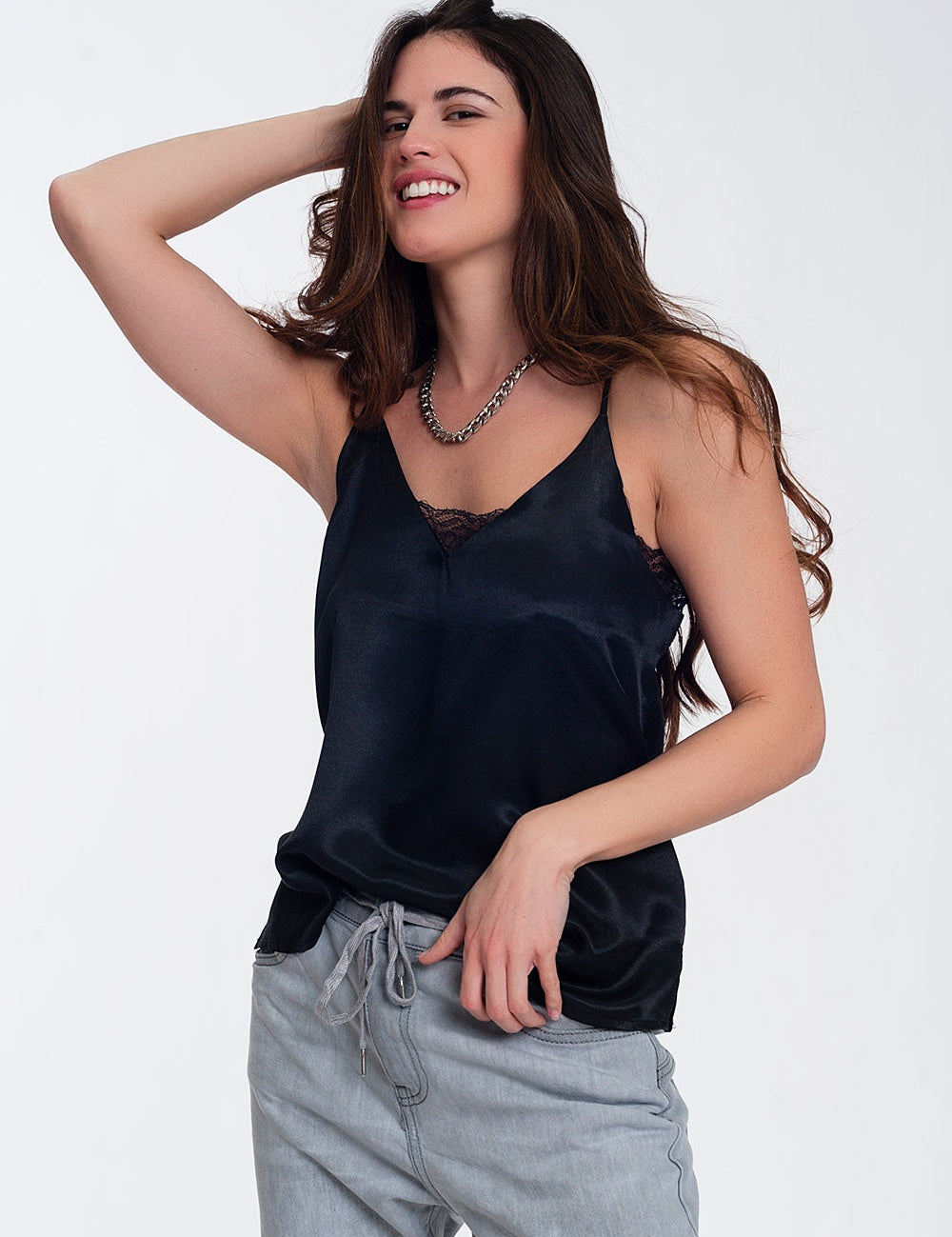 Woman wearing Noctelle black lace accent cami with V-neck and slender straps, paired with jeans, showcasing a chic, versatile look.