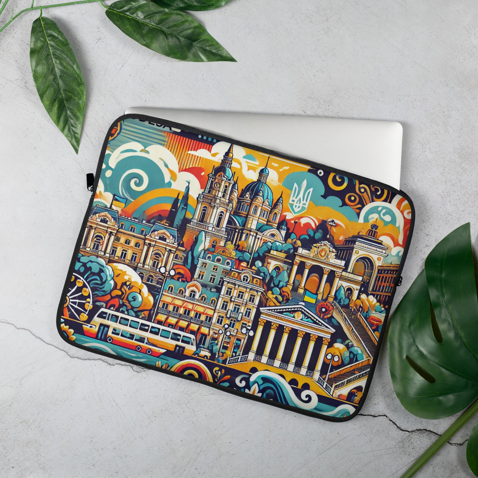 Odesa Cityscape laptop sleeve with Tryzub and vibrant design on a desk with plants.