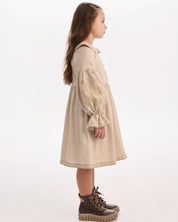 Side view of a girl wearing a beige embroidered linen dress, showcasing Ukrainian folk motifs, highlighting Ukrainian craftsmanship