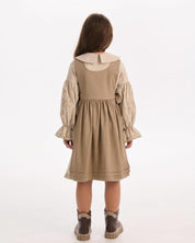 Back view of a girl wearing a beige linen embroidered Ukrainian vyshyvanka dress with long sleeves, showcasing Slavic ethnic style.