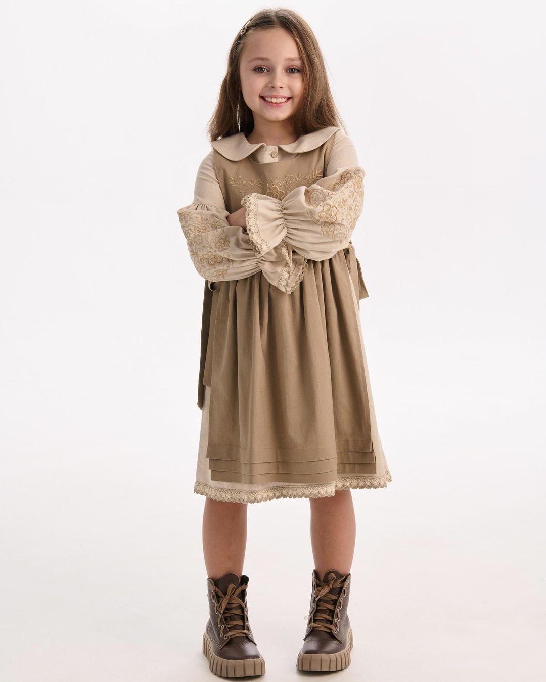 Girl wearing a linen embroidered dress with Ukrainian folk motifs, embodying Slavic ethnic style, brings elegance and cultural charm.