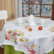 Ukrainian Easter table decorated with linen embroidered tablecloth, set with white tea set and ornamental balls.