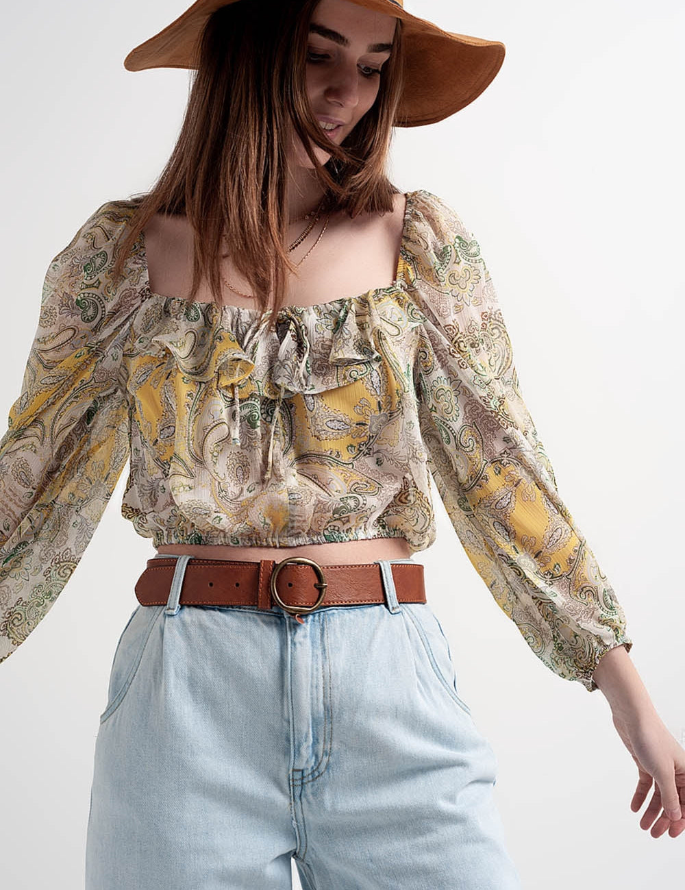 Model wearing Sirellin Sheer Boho Top, translucent chiffon-like fabric, relaxed silhouette, tie detail, paired with jeans and hat