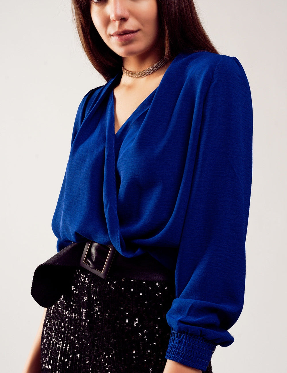 Model wearing Alcenyra Wrap Satin Blouse in blue with shirred cuffs, perfect for elegant evening or chic daytime looks.