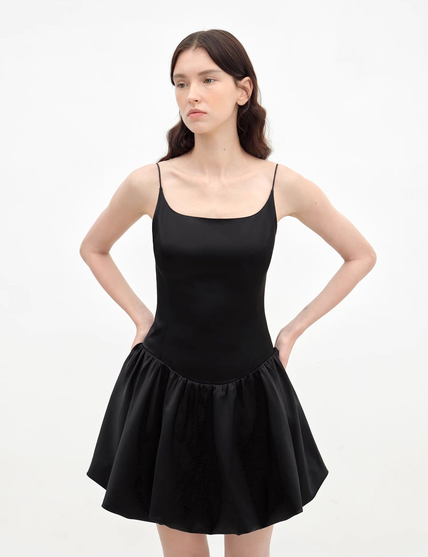 Woman wearing Lyrielle Satin Ballet Slip Dress in black, featuring a fluid silhouette, slender straps, and voluminous skirt.