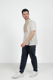 Man wearing a traditional Ukrainian embroidered linen shirt with geometric pattern and short sleeves, styled with jeans.