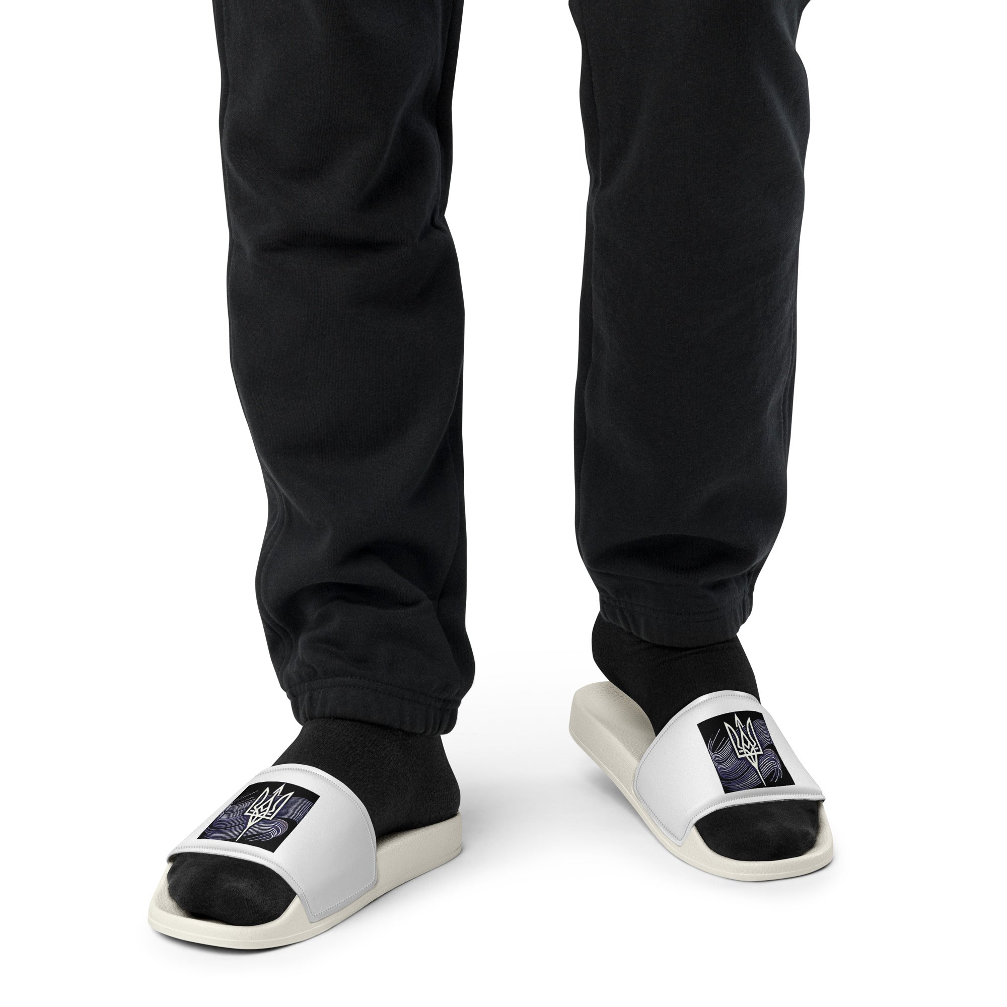 Black 'Pidkradyli' sandals with Tryzub emblem, worn with black pants and socks, showcasing a modern, comfortable design.
