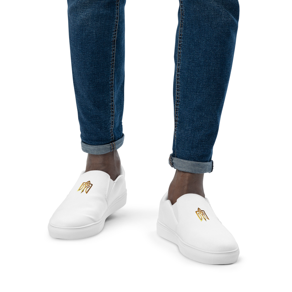 White slip-on canvas shoes with gold Ukrainian Trizub, worn with blue jeans for a stylish and comfortable look.