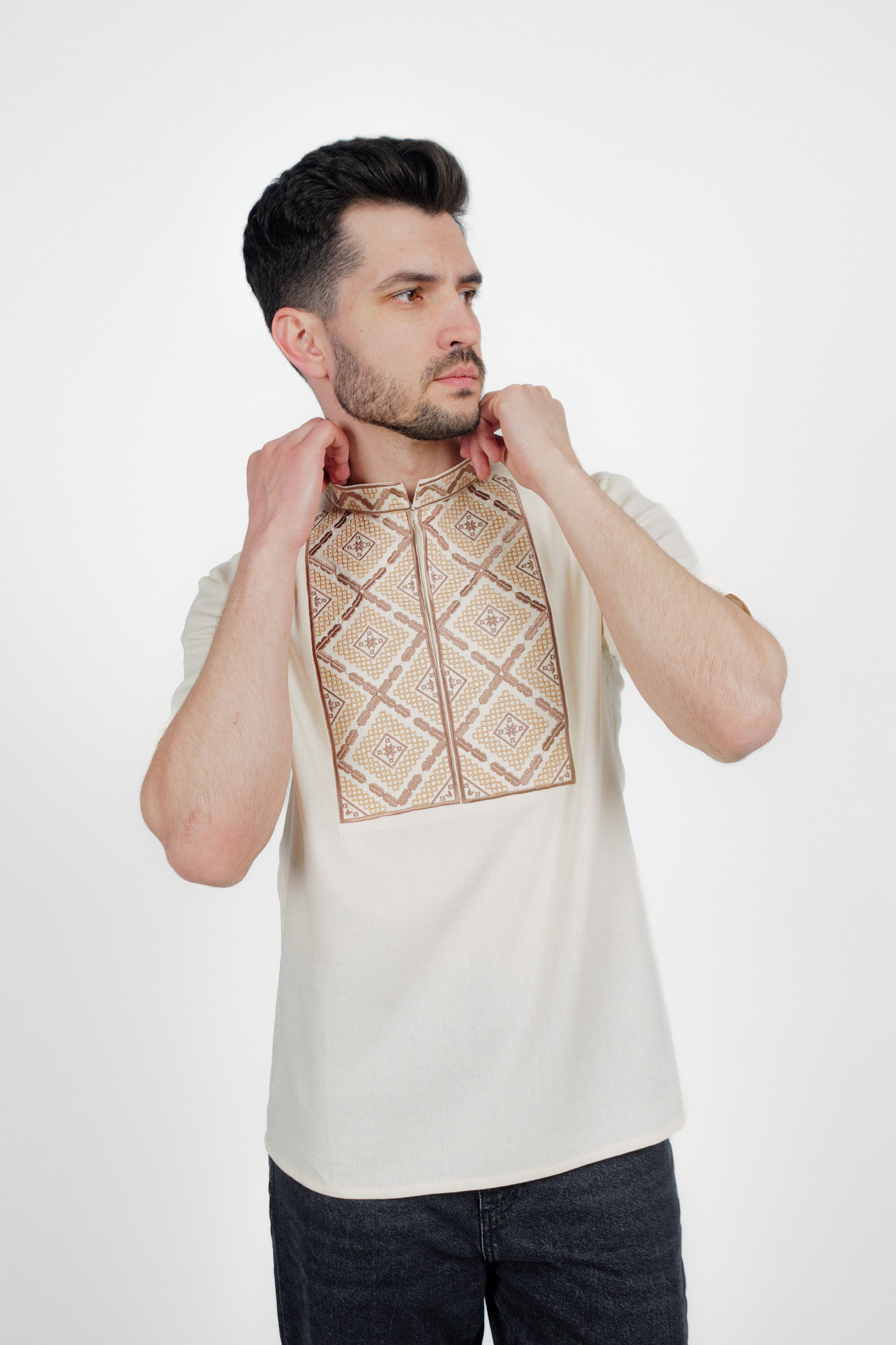 Man wearing a men's short sleeve Ukrainian embroidered shirt with geometric pattern, crafted from linen-cotton blend.