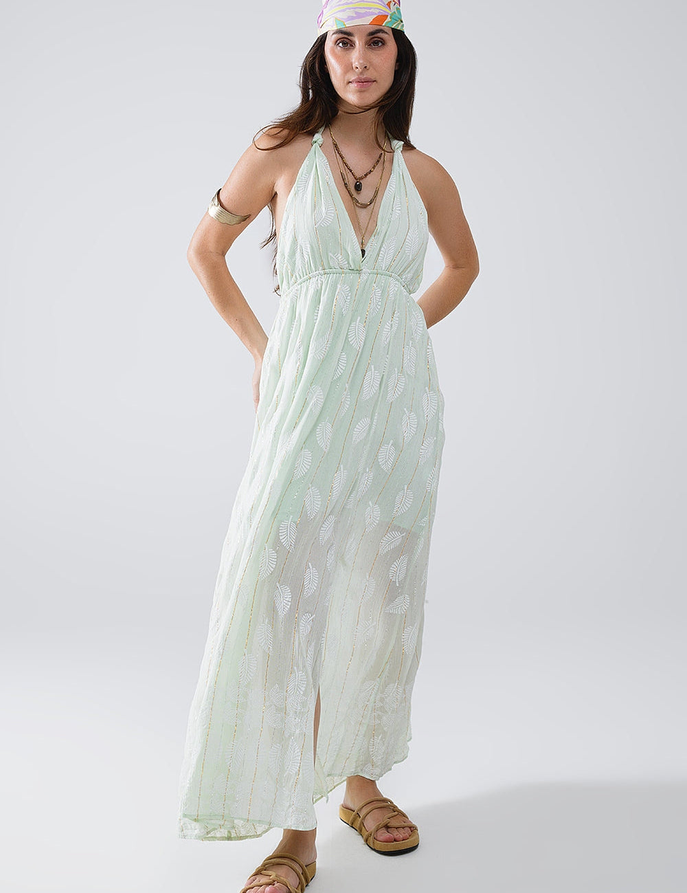 Woman wearing Mintara Leaf-Lurex Halter Dress with mint-leaf print and halter neckline, barefoot in casual boho style.