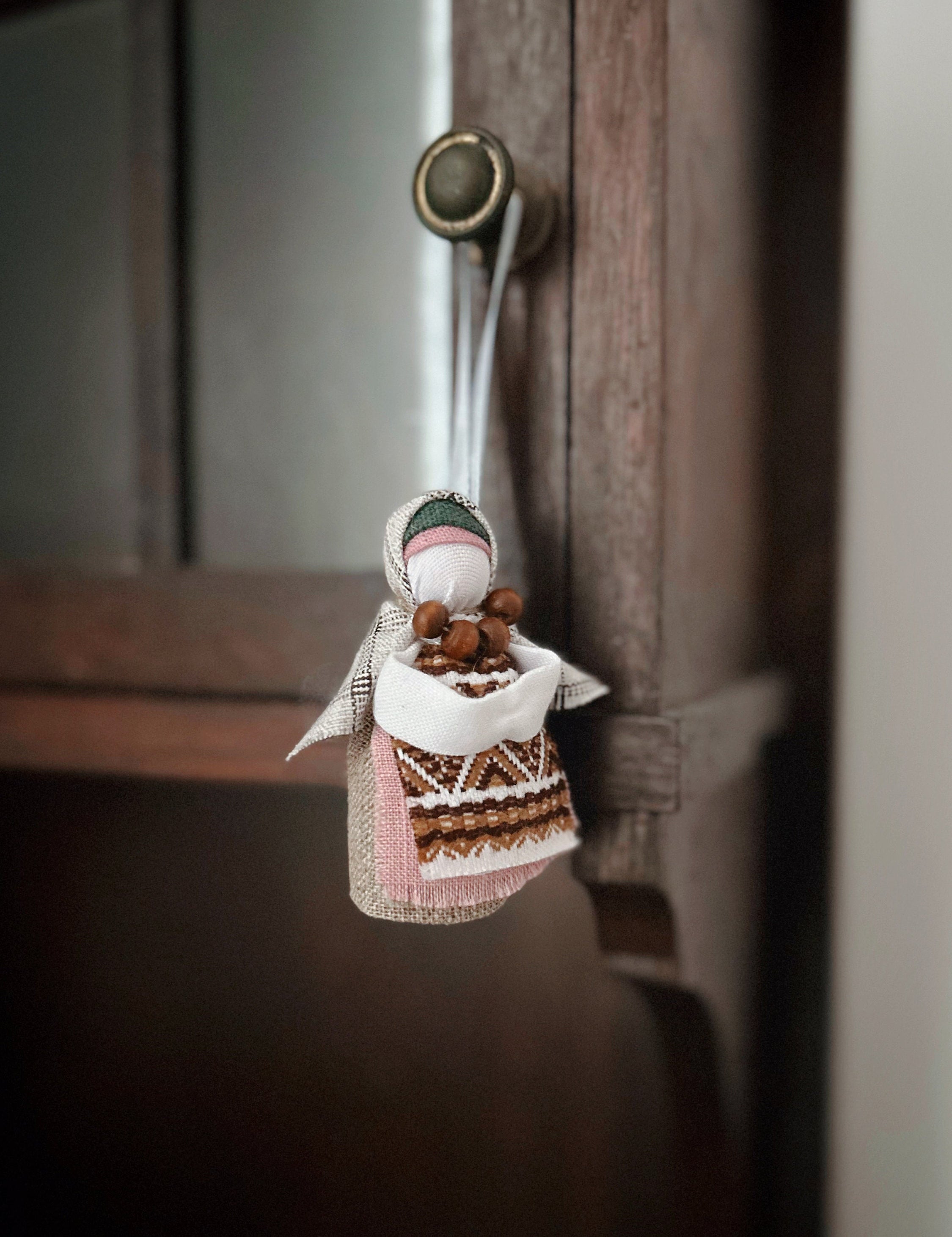 Handmade Ukrainian Motanka Doll "Little Bereginiya" with horseshoe, charming folk art amulet hanging for home decor and luck.