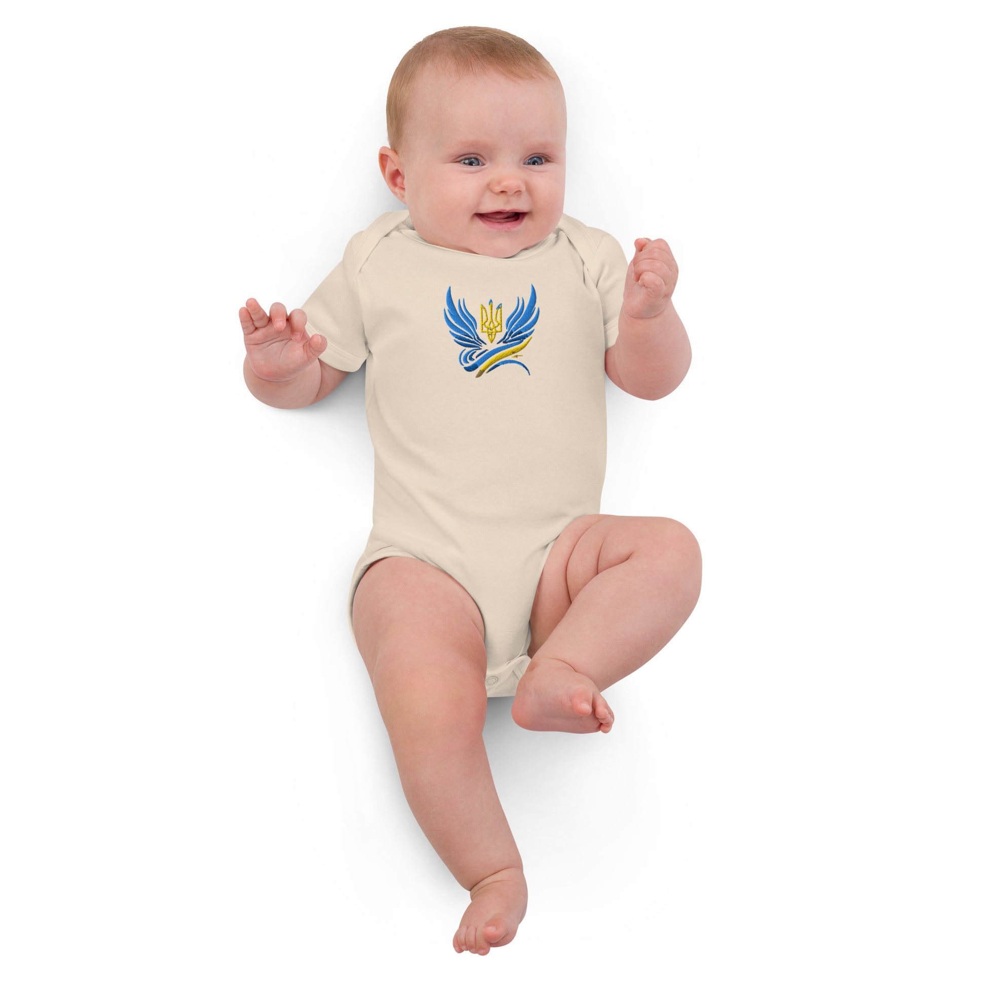 Baby wearing organic cotton bodysuit with Ukrainian Tryzub logo, showcasing soft, eco-friendly fabric and heritage pride.