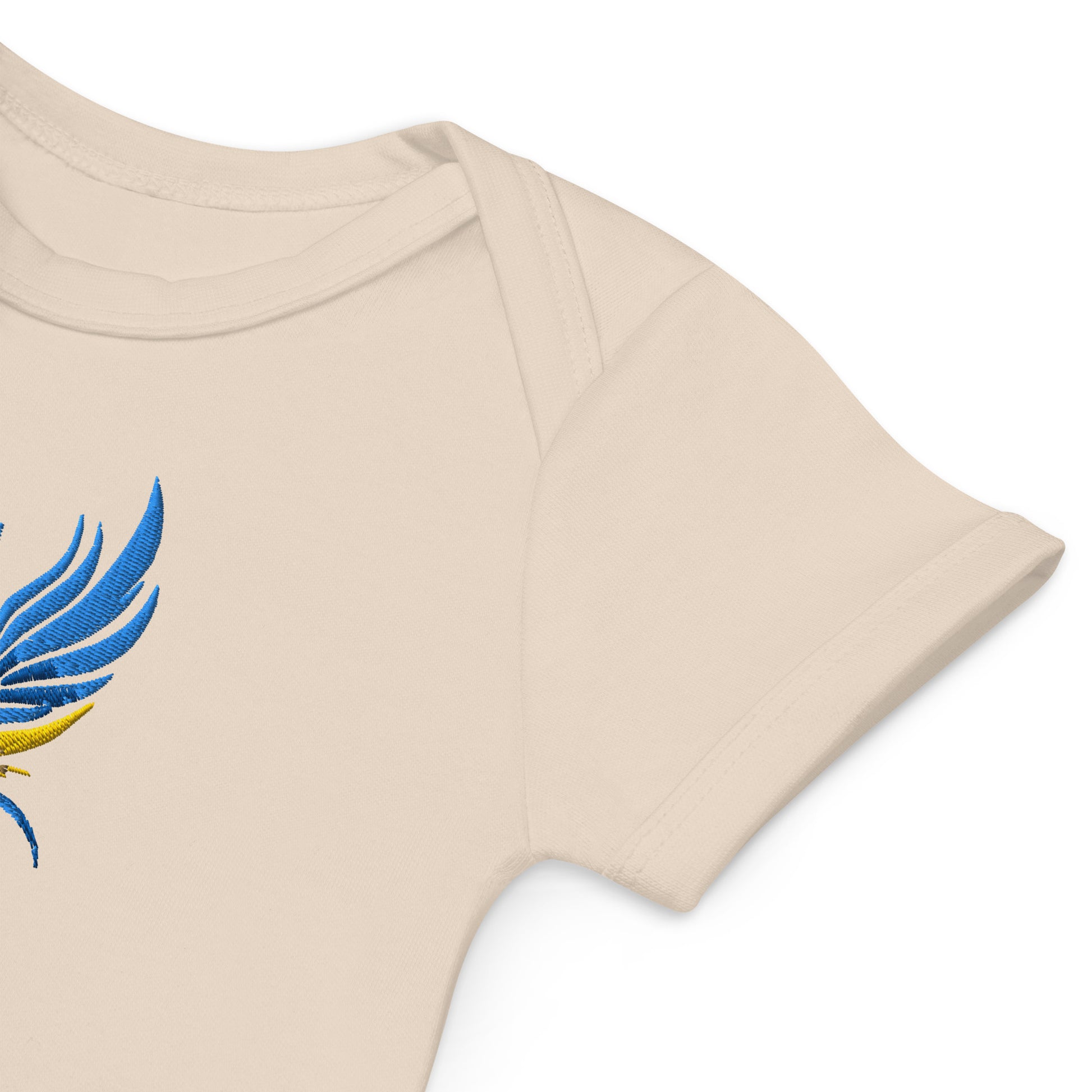 Organic cotton baby bodysuit with blue and yellow Tryzub logo embroidery on beige fabric.