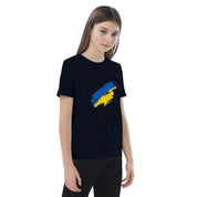 Girl wearing organic cotton kids' t-shirt with Ukrainian flag design, promoting sustainability and Ukrainian pride.
