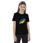 Girl wearing an organic cotton kids' t-shirt with a Ukrainian flag design, promoting sustainability and patriotism.