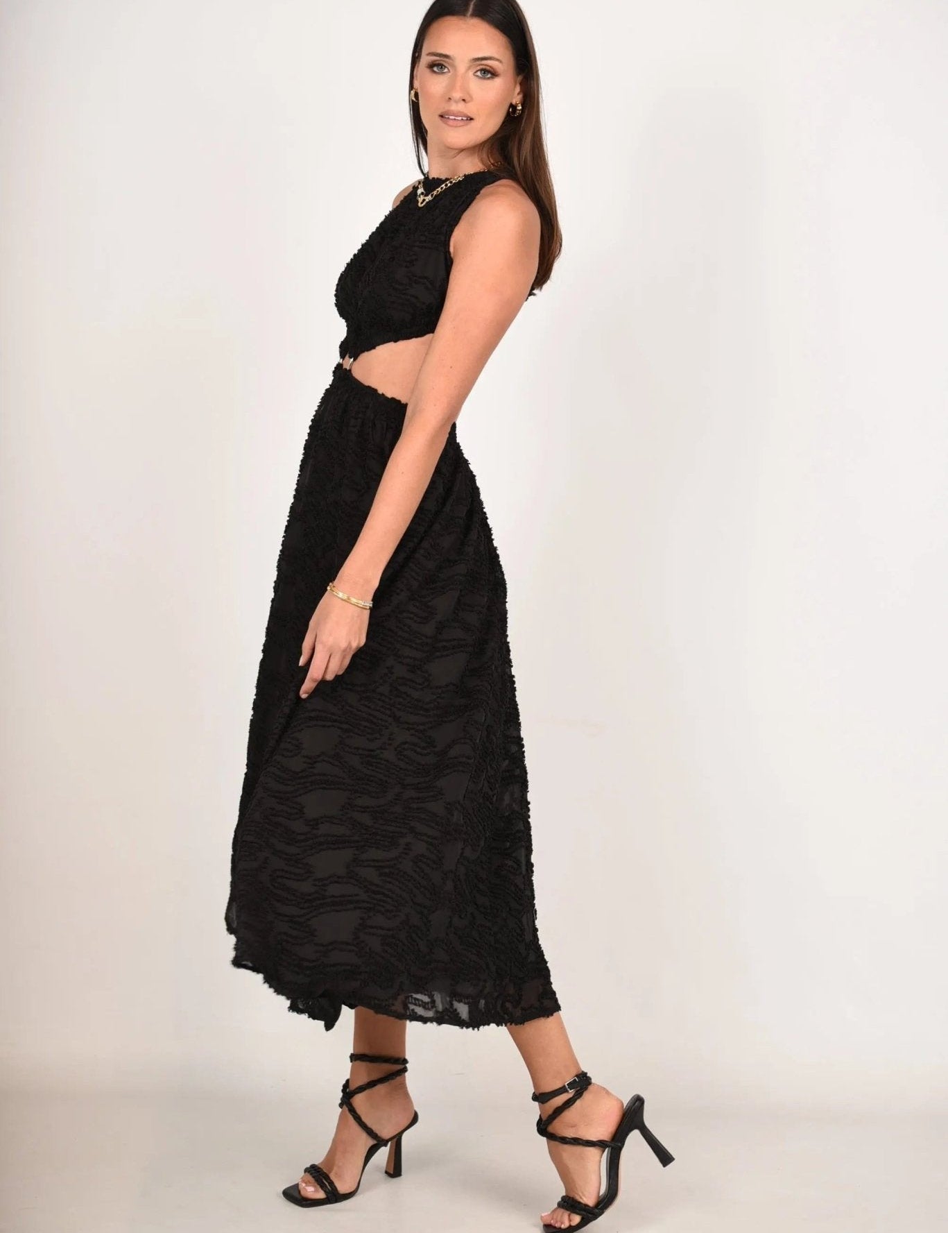 Model wearing Whispering Jacquard Maxi Dress with open back, cinched waist, paired with stylish sandals for an elegant summer look.