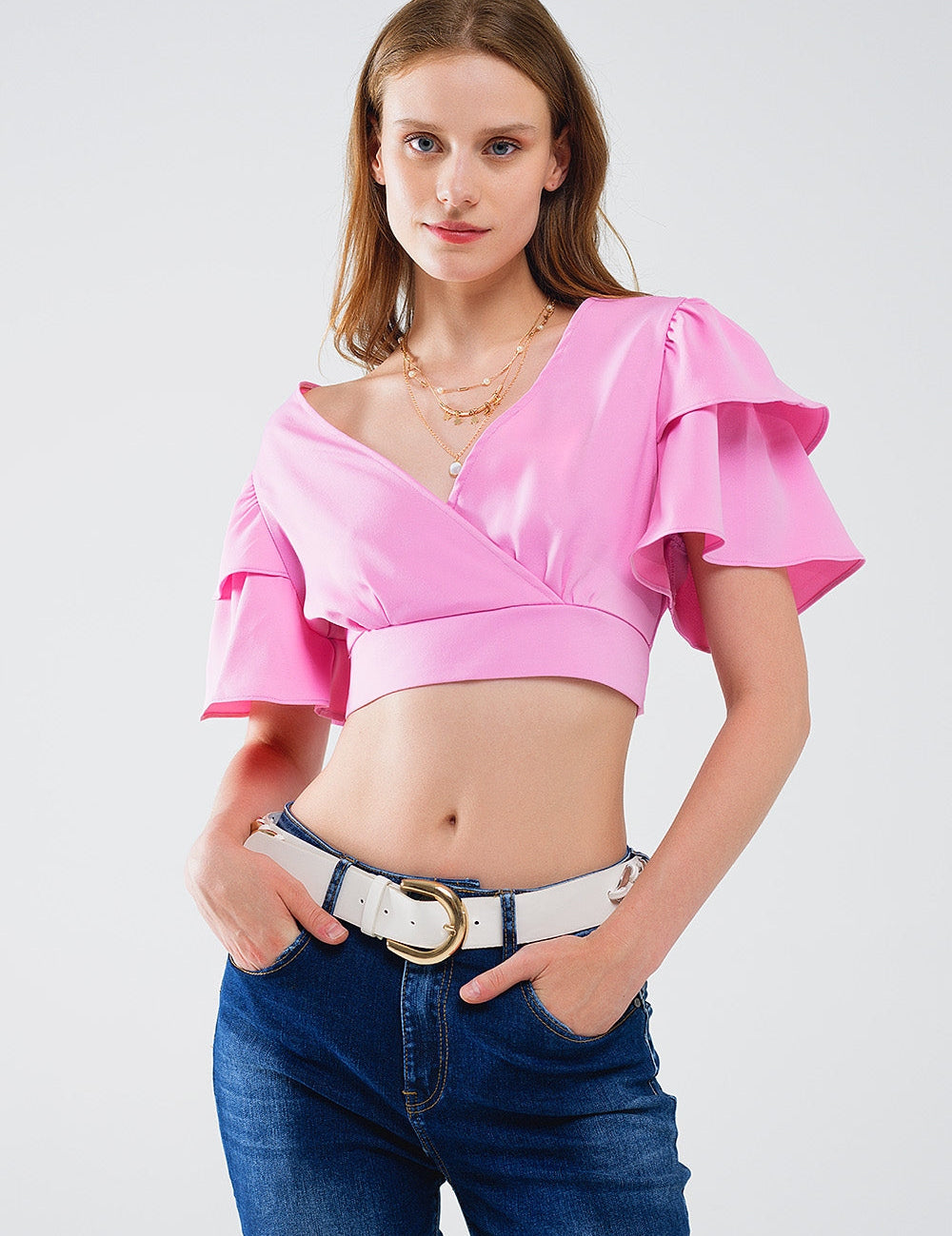 Model wearing Callessa Draped-Back Pink Blouse with V-neckline and short sleeves, showcasing a chic and playful summer style.
