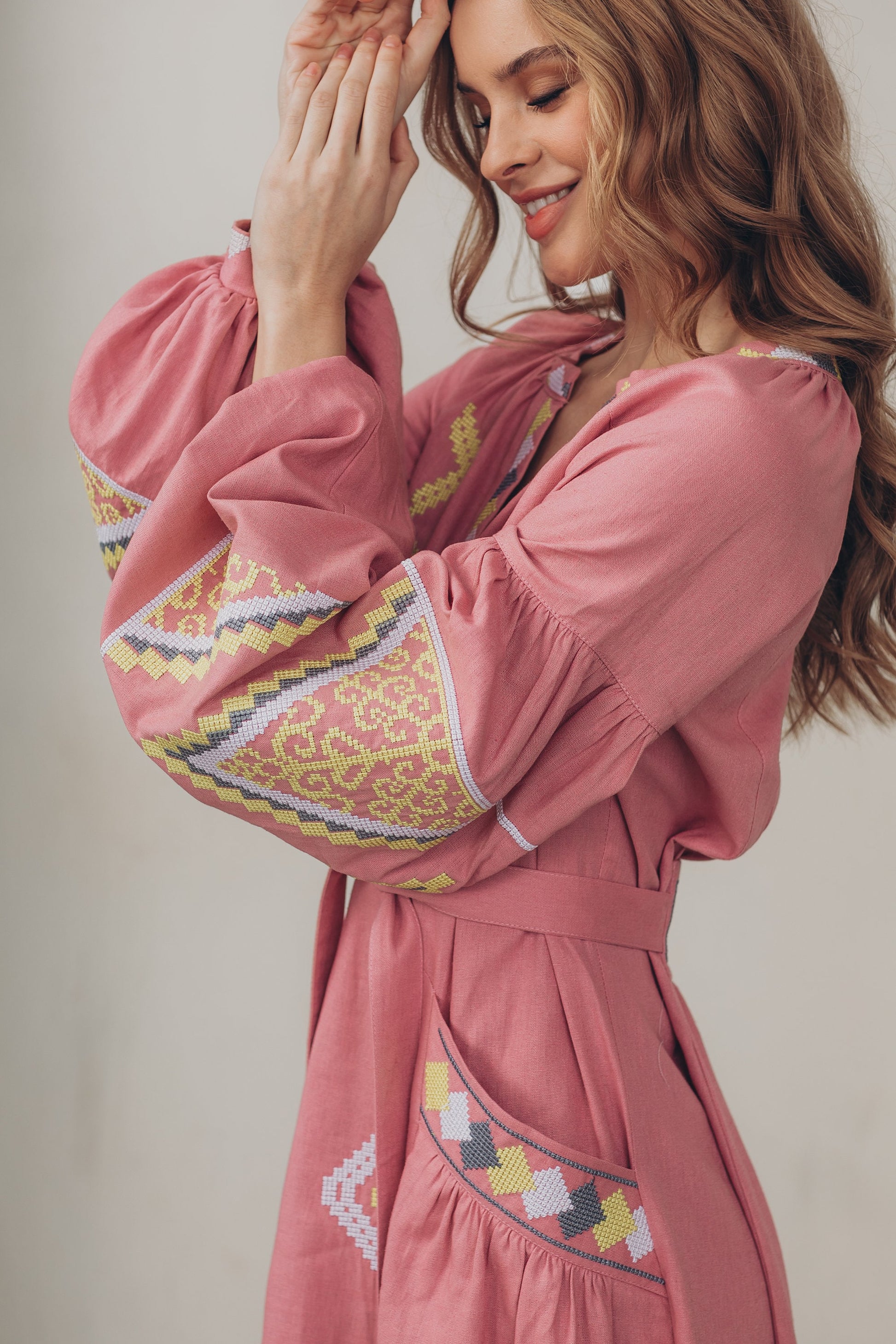 Pink linen embroidered Vyshyvanka dress in Ukrainian boho folk style with colorful patterns, belt, and pockets.
