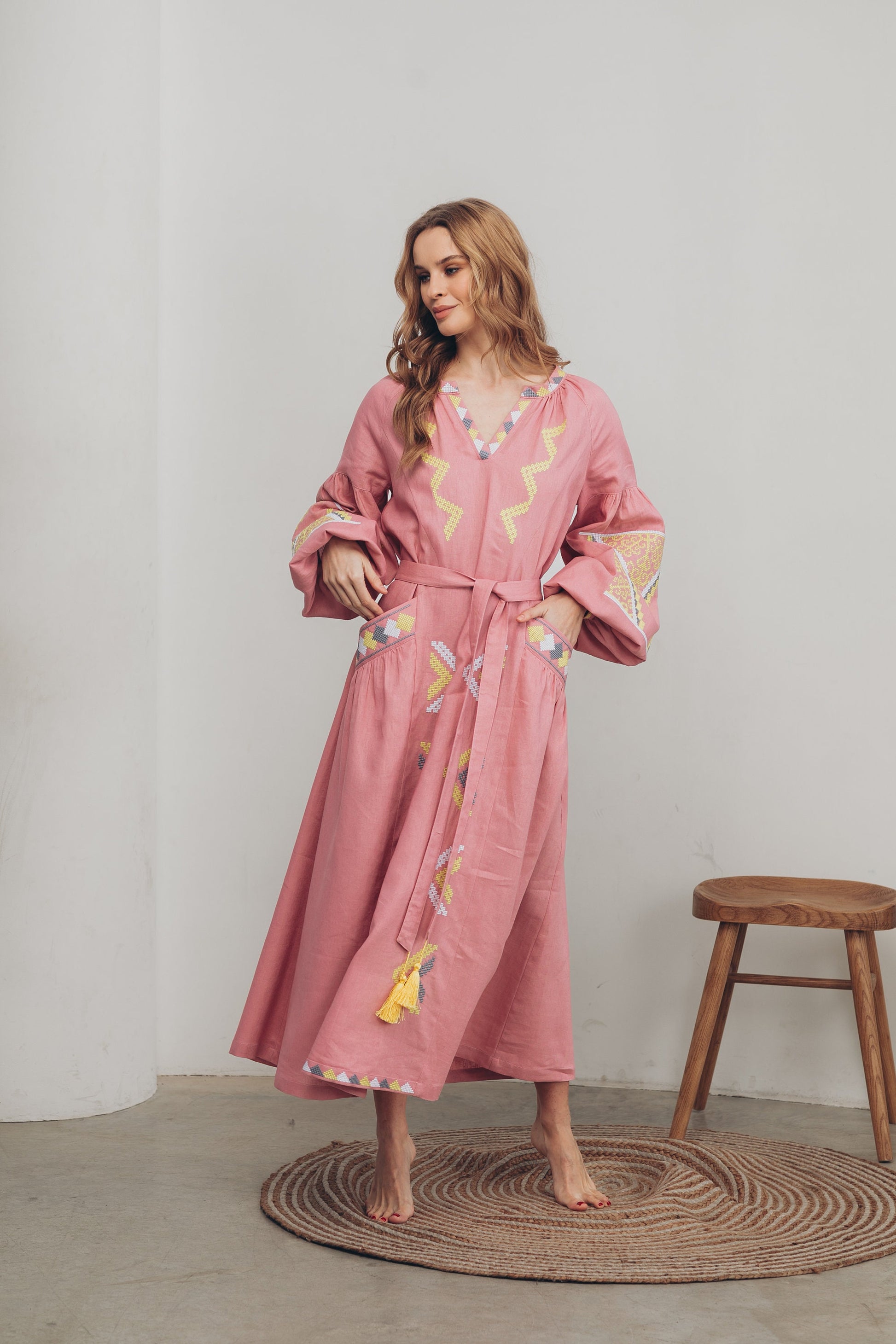 Pink linen Vyshyvanka dress in Ukrainian boho style with embroidery, belt, and pockets, blending tradition and modern fashion.