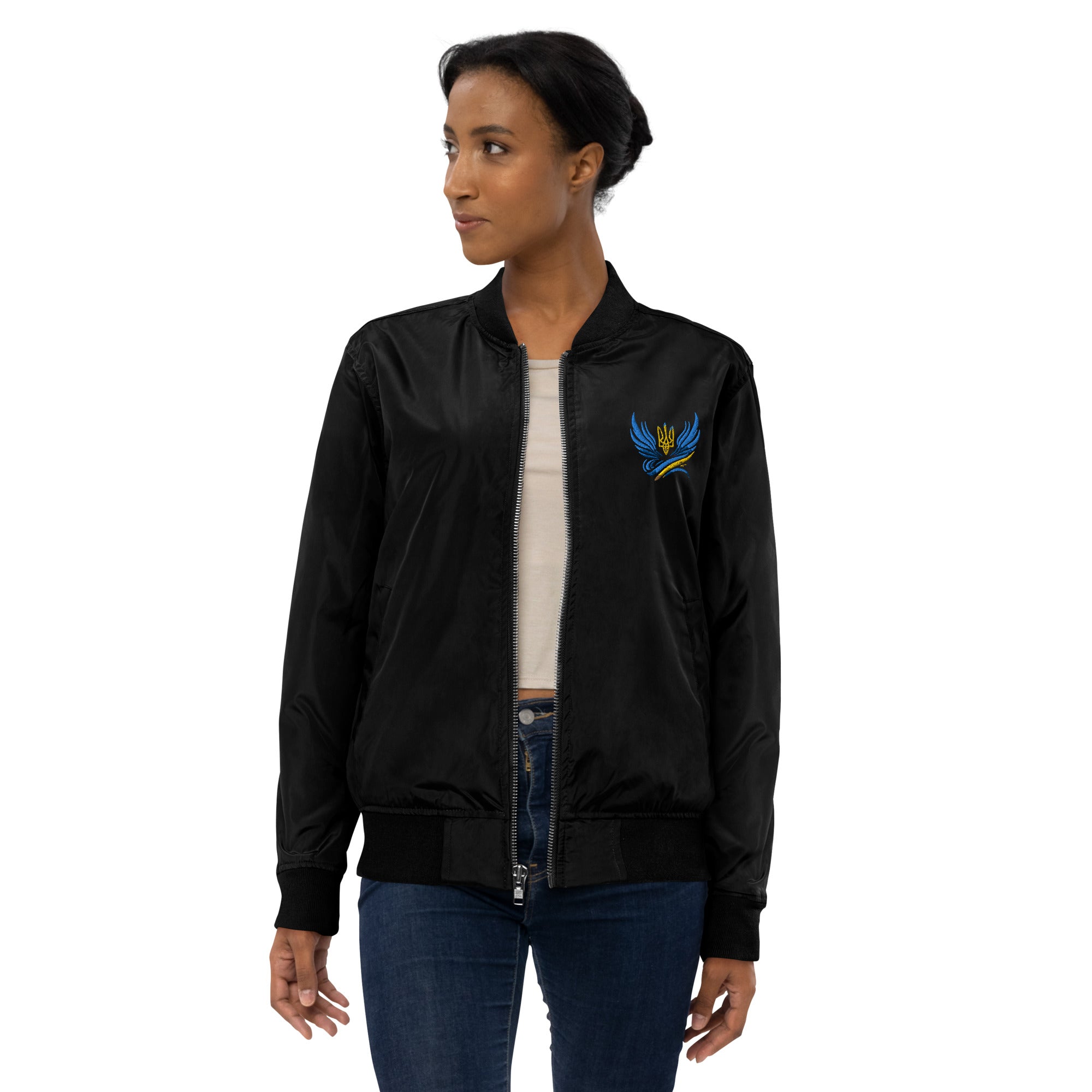 Woman wearing Ukrainian premium recycled bomber jacket with Trizub emblem, eco-friendly fashion, unisex style in black.