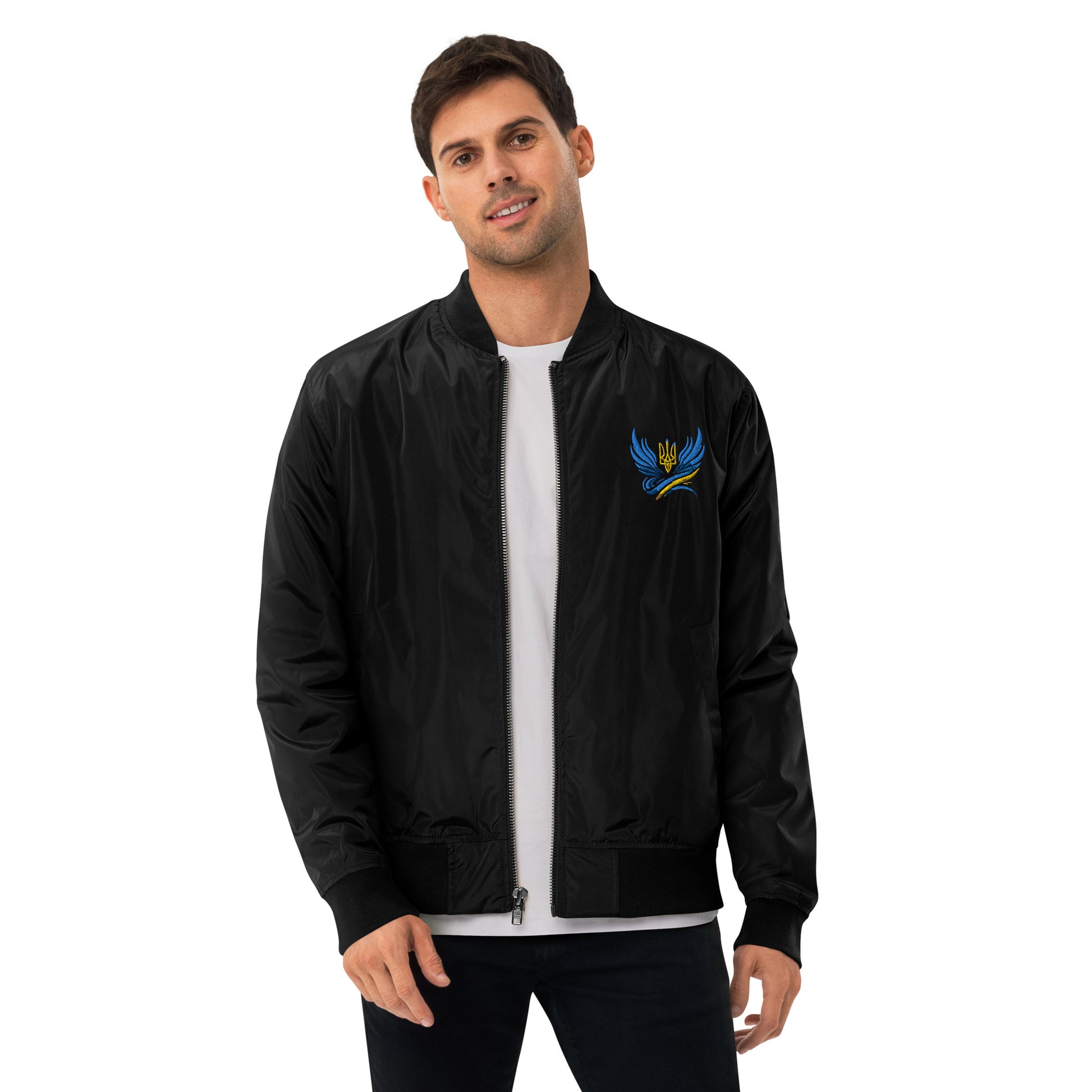 Man wearing black recycled polyester bomber jacket from Trizub Collection with Ukrainian emblem, showcasing relaxed fit.