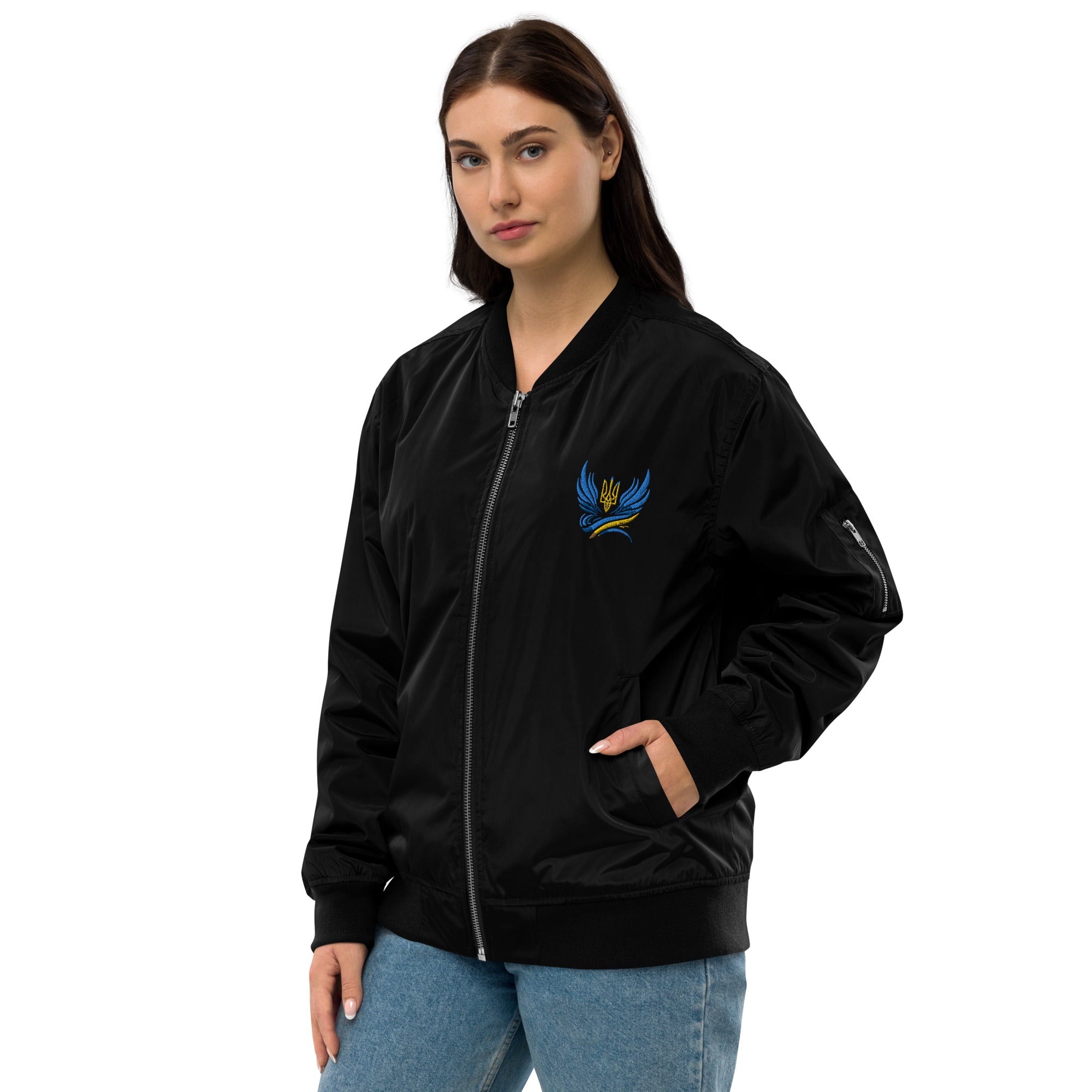 Woman wearing Ukrainian premium recycled bomber jacket in black with Trizub emblem, eco-friendly fashion, relaxed unisex fit.