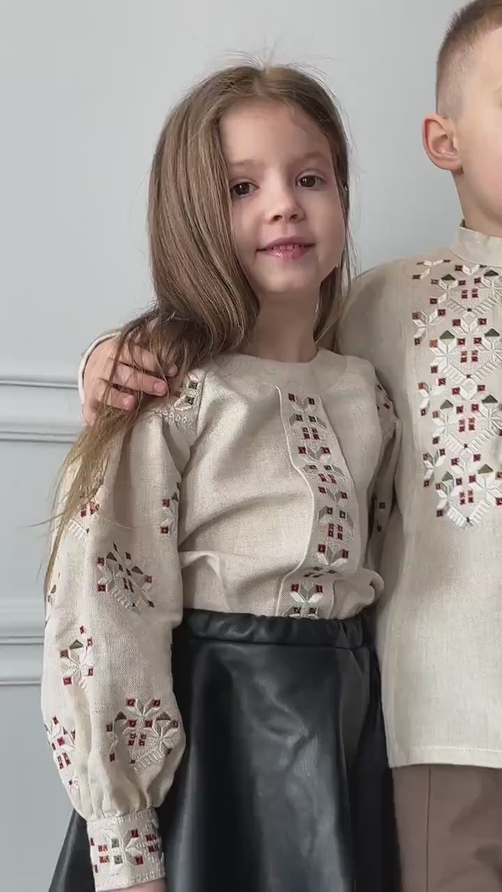 Child wearing traditional Ukrainian embroidered shirt with intricate patterns, smiling. Ideal for cultural events and celebrations.